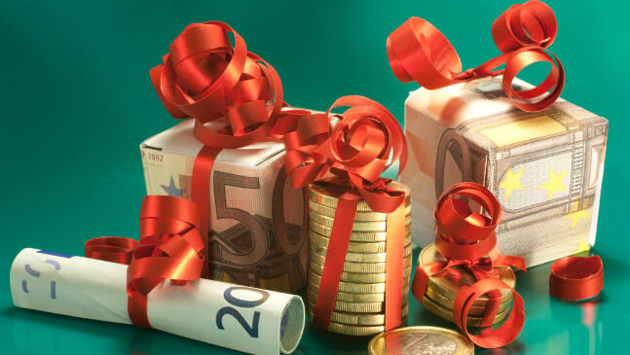 Zahlreiche Geldscheine und Münzen sind zu kleinen Weihnachtsgeschenken gestaltet.