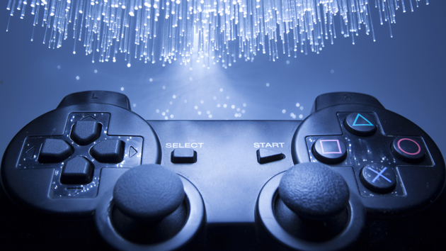 Nahaufnahme eines Gamecontrollers vor einem blauen Hintergrund mit Lichteffekten