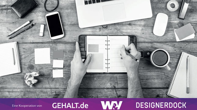 Draufansicht von einem Schreibtisch, auf dem ein Terminkalender, ein Smartphone, Stifte und weitere Büroartikel liegen.