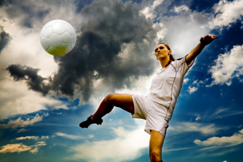 Frauenfußball: Fußballerin nimmt athletisch einen Ball per Volleyschuss