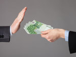 Ein Mann verzichtet mit einer ablehnenden Geste auf ihm angebotenes Geld.