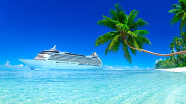 Kreuzfahrtschiff mit blauem Himmel, türkisfarbenem Meer und weißem Sand, grünen Palmen.