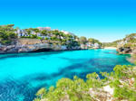 Cala Santanyi-Mallorca-Spanien-Küste. Blaues Meer, Sandküste und weiße Gebäude.