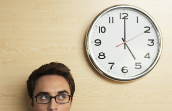 Mann neben Wanduhr