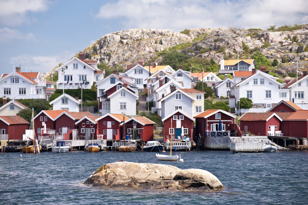 Eine Bucht in Schweden mit kleinen Booten und typisch schwedischen Häuschen im Hintergrund