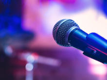 Mikrofon auf der Bühne auf violettem Hintergrund.
