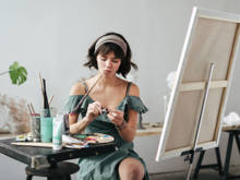 Eine junge Frau malt mit Ölfarben auf einer Leinwand