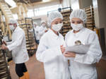 Frauen, die in einer Lebensmittelfabrik arbeiten und sich eine Checkliste auf einem Klemmbrett ansehen